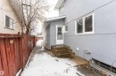 Gray stucco exterior with white-framed windows, a white entry door, and concrete steps - 17716 84 Ave, Edmonton, AB  - Outdoor With Exterior 