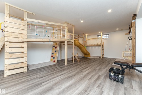 Recreational room featuring wood-finish flooring, recessed lighting, and a large custom-built wooden play structure - 17716 84 Ave, Edmonton, AB - Indoor