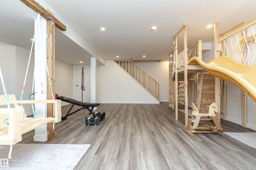 Spacious lower level featuring wood-finish flooring, recessed lighting, and white walls - 17716 84 Ave, Edmonton, AB - Indoor