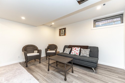 Finished lower level featuring recessed lighting, a window, wood-finish flooring, and white baseboards - 17716 84 Ave, Edmonton, AB - Indoor