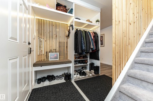 Entryway featuring a built-in bench, integrated lighting, and vertical wood slat detailing - 17716 84 Ave, Edmonton, AB - Indoor