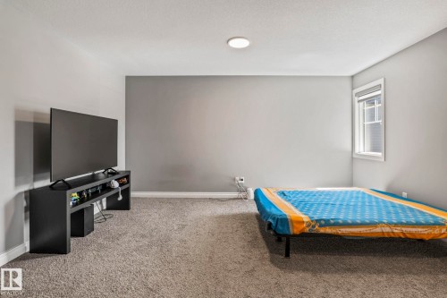Carpeted room featuring a single window with white trim, a flush-mount ceiling light, and light gray painted walls - 5142 23A Avenue, Edmonton, AB - Indoor