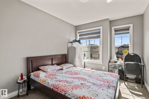 Bedroom featuring two windows with blinds, gray painted walls, and carpet flooring - 5142 23A Avenue, Edmonton, AB - Indoor Photo Showing Bedroom