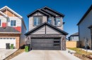 Modern two-story residence featuring a stone and siding facade, an integrated two-car garage with frosted glass panels, and multiple large windows - 5142 23A Avenue, Edmonton, AB  - Outdoor 