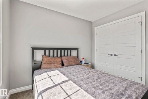 Recessed panel closet doors with matte black hardware - 5142 23A Avenue, Edmonton, AB - Indoor Photo Showing Bedroom