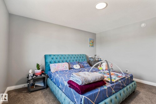 Carpeted flooring complements light gray walls, with a white baseboard trim - 5142 23A Avenue, Edmonton, AB - Indoor Photo Showing Bedroom