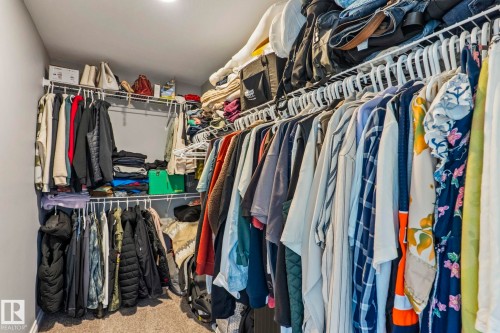 Walk-in closet featuring wire shelving, multiple hanging rods, recessed lighting, and carpet flooring - 5142 23A Avenue, Edmonton, AB - Indoor With Storage