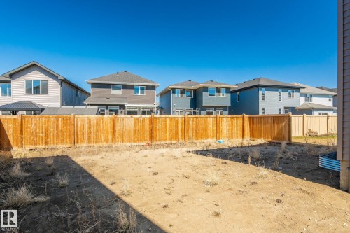 Expansive backyard space featuring a new wood fence and clear sky backdrop - 5142 23A Avenue, Edmonton, AB - Outdoor