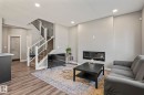 Spacious living area featuring wood-finish flooring, recessed lighting, and a contemporary linear fireplace - 5142 23A Avenue, Edmonton, AB  - Indoor With Fireplace 