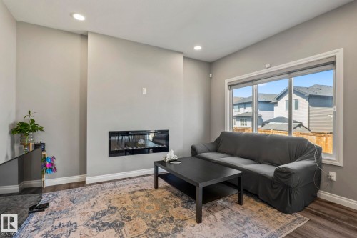 Living area featuring a sleek linear electric fireplace - 5142 23A Avenue, Edmonton, AB - Indoor Photo Showing Living Room With Fireplace
