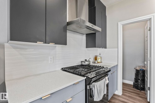Modern kitchen featuring matte gray cabinetry with gold-tone hardware - 5142 23A Avenue, Edmonton, AB - Indoor Photo Showing Kitchen With Upgraded Kitchen