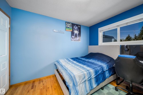 Spacious room featuring wood-finish flooring and a large window - 14808 96 Street, Edmonton, AB - Indoor Photo Showing Bedroom