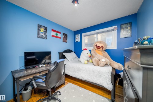 Brightly painted room with wood-finish flooring, a white ceiling, and a large window - 14808 96 Street, Edmonton, AB - Indoor Photo Showing Office