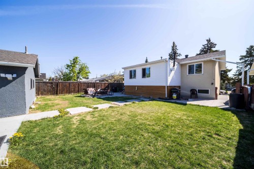 Expansive backyard featuring a green lawn, concrete patio, and a privacy fence - 14808 96 Street, Edmonton, AB - Outdoor