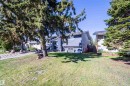 Split-level residence featuring blue siding, white trim, and a dark shingled roof - 14808 96 Street, Edmonton, AB  - Outdoor 
