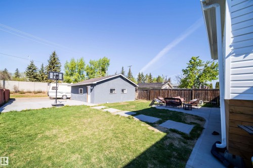 Spacious backyard featuring a detached garage, concrete patio, and a wooden perimeter fence - 14808 96 Street, Edmonton, AB - Outdoor