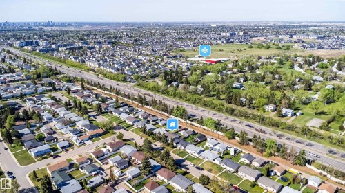 Aerial perspective showcasing a residential area with a prominent highway and distant urban skyline - 14808 96 Street, Edmonton, AB - Outdoor With View