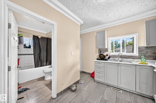 Kitchenette with gray cabinetry, white countertops, and a stainless steel sink - 12627 71 Street Nw, Edmonton, AB 