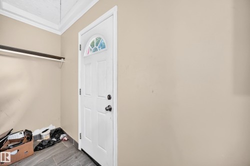 White door with an arched window, tile flooring, and a wall-mounted shelf - 12627 71 Street Nw, Edmonton, AB 
