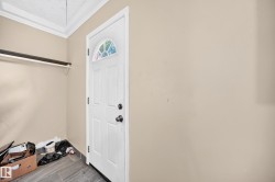 White door with an arched window, tile flooring, and a wall-mounted shelf - 