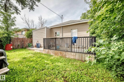 Rear exterior featuring horizontal siding, a private deck with black railings, and a fenced yard - 12627 71 Street Nw, Edmonton, AB 