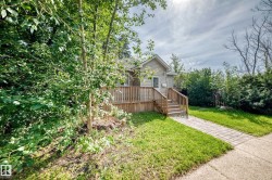 Siding exterior with a gable roof, wood deck, and wood railing with steps - 