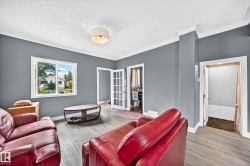Wood-finish flooring, white trim, and a ceiling-mounted light fixture - 