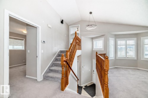 This property features a spacious interior with light gray walls and plush gray carpeting throughout - 8008 97 St, Morinville, AB - Indoor Photo Showing Other Room