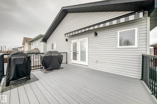 The property features a spacious deck with dark railings, providing an outdoor area - 8008 97 St, Morinville, AB - Outdoor With Deck Patio Veranda With Exterior
