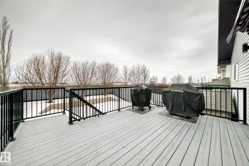 The property features a spacious deck with light-colored decking and black railings, offering views of the yard - 8008 97 St, Morinville, AB - Outdoor With Exterior
