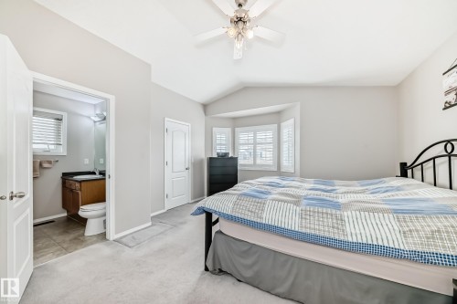 The property includes a bedroom with neutral-toned walls, carpeted flooring, and a ceiling fan with integrated lighting - 8008 97 St, Morinville, AB - Indoor Photo Showing Bedroom