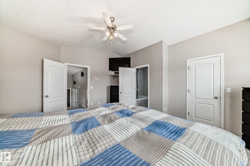 The room features a vaulted ceiling with a ceiling fan, light-colored walls, and white doors - 8008 97 St, Morinville, AB - Indoor Photo Showing Bedroom