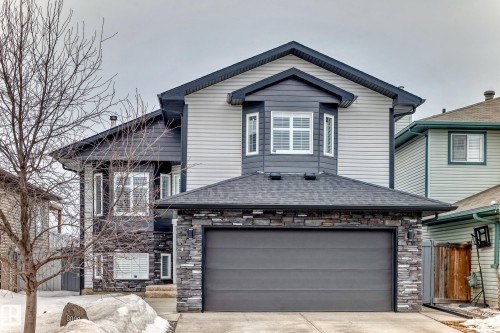 The property features a stone and siding exterior, a two-car garage, and a peaked roof - 8008 97 St, Morinville, AB - Outdoor