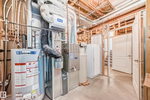 The property features essential utility systems including a water heater and furnace, alongside visible electrical and plumbing infrastructure - 8008 97 St, Morinville, AB - Indoor Photo Showing Basement