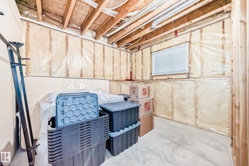 The property features an unfinished space with exposed wooden beams, insulation, and a window - 8008 97 St, Morinville, AB - Indoor Photo Showing Basement