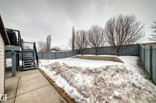 The property features a concrete patio and stairs leading to an elevated deck - 8008 97 St, Morinville, AB - Outdoor