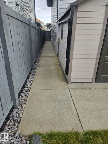 The property features a concrete walkway with a gravel border, a fence, and exterior siding - 8008 97 St, Morinville, AB - Outdoor With Exterior