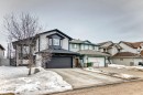 The property features a two-story design with a dark gray garage door, light-colored siding, and dark trim details - 8008 97 St, Morinville, AB  - Outdoor With Facade 