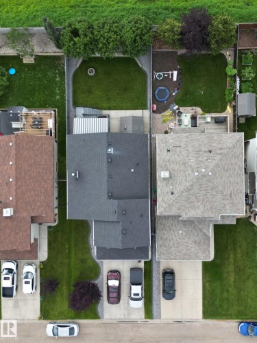 The property features a dark gray shingled roof, a paved driveway, and a well-maintained lawn - 8008 97 St, Morinville, AB - Outdoor