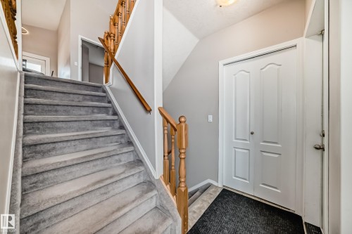 The property features a staircase with carpeted treads and a wooden handrail - 8008 97 St, Morinville, AB - Indoor Photo Showing Other Room