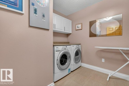 Once again the laundry has refaced cabinet doors and textured countertops.  Washer and Dryer say with the condo. - 101 10903 21 Avenue Nw, Edmonton, AB - Indoor Photo Showing Laundry Room