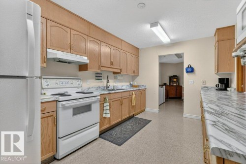 The great room offers a full kitchen with appliances, dishes and pots and pans. - 101 10903 21 Avenue Nw, Edmonton, AB - Indoor Photo Showing Kitchen