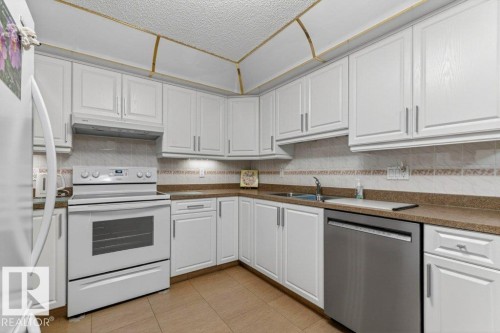 Cabinet doors have been refaced and new countertops installed. - 101 10903 21 Avenue Nw, Edmonton, AB - Indoor Photo Showing Kitchen With Double Sink