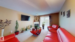 Living area featuring neutral wall tones, textured ceiling, and light-colored carpet flooring - 