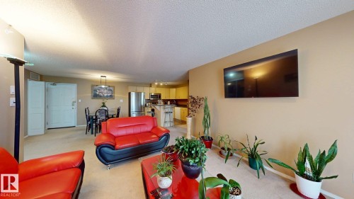 Open-concept living space featuring neutral wall tones and light-colored carpeting - 405 16303 95 Street Nw, Edmonton, AB - Indoor Photo Showing Living Room