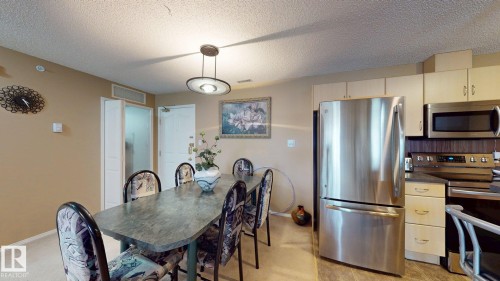 Dining area with a modern drum pendant light fixture - 405 16303 95 Street Nw, Edmonton, AB - Indoor