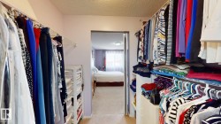 Walk-through closet featuring built-in wire shelving and hanging rods - 
