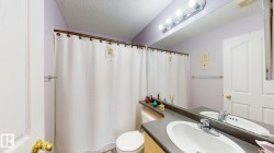 Bathroom vanity featuring a single basin sink, chrome faucet, and expansive mirror with overhead lighting - 