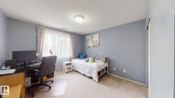 Carpeted room featuring light blue walls and a textured ceiling - 