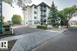 Multi-story building featuring balconies, white exterior siding, and blue trim accents - 